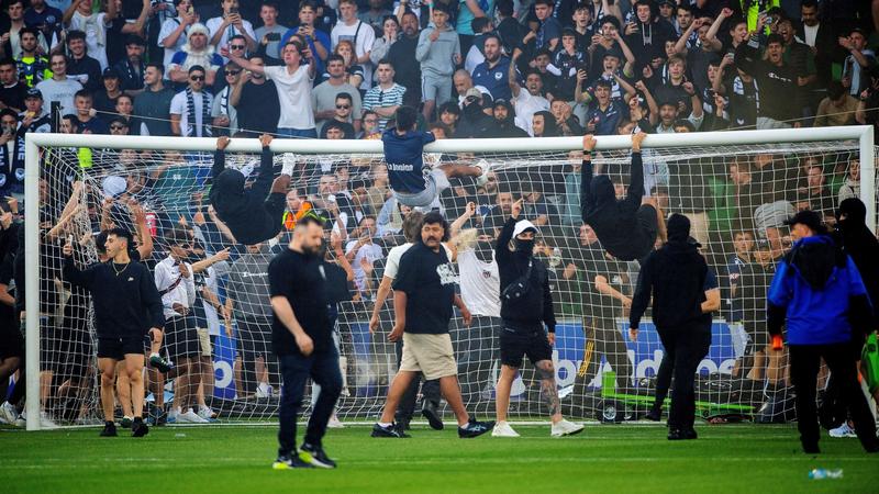 Goalkeeper injured as fans invade pitch in Melbourne derby