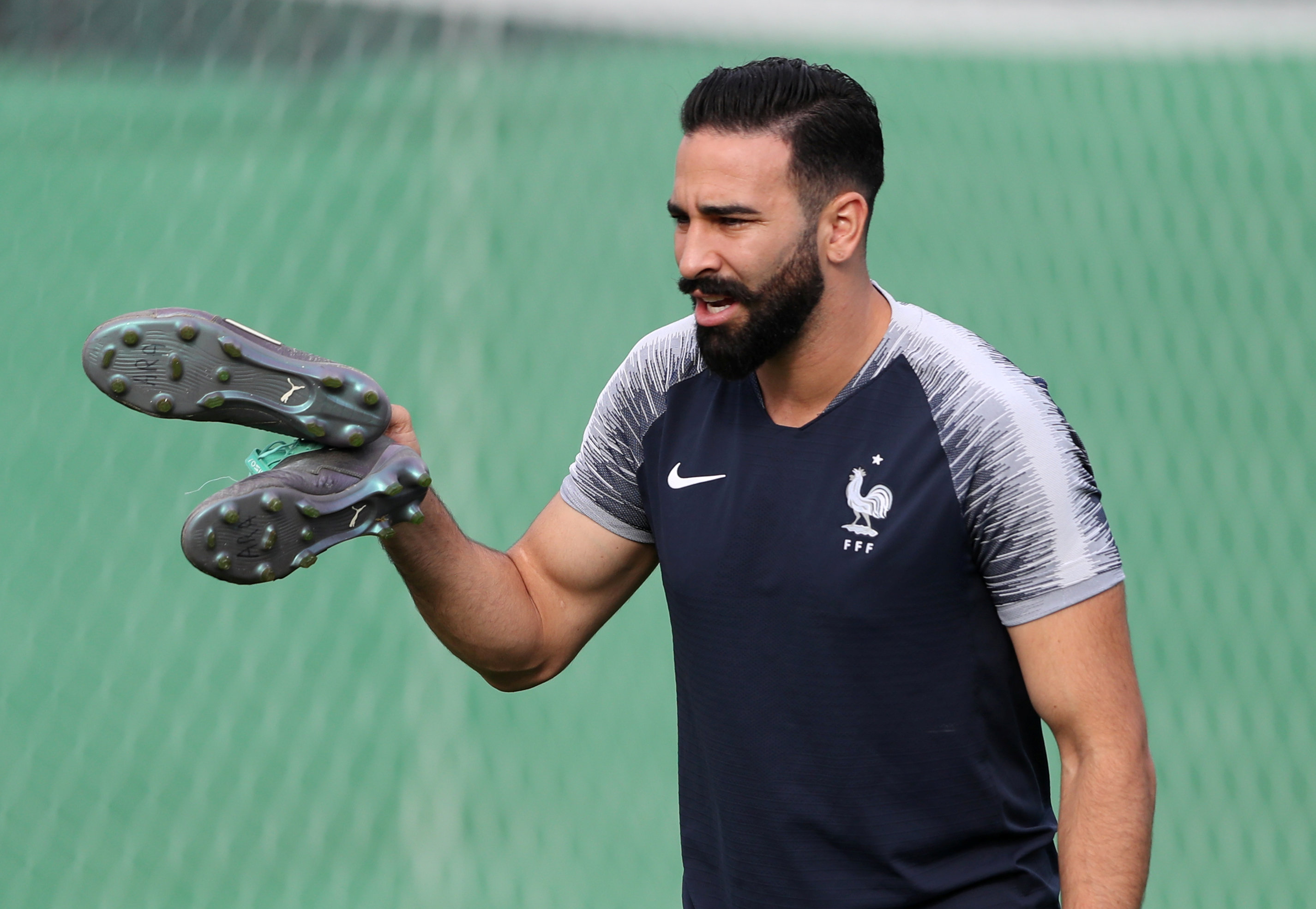 Adil Rami chaussures à la main